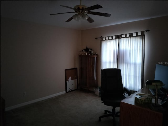 unfurnished office featuring carpet floors, plenty of natural light, baseboards, and a ceiling fan