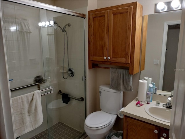 bathroom with toilet, a shower stall, and vanity