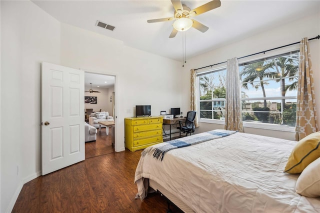 bedroom featuring dark wood-style flooring, lofted ceiling, visible vents, ceiling fan, and baseboards