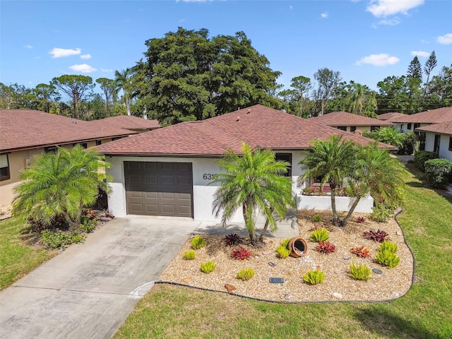 view of front facade with a garage, roof with shingles, driveway, and stucco siding