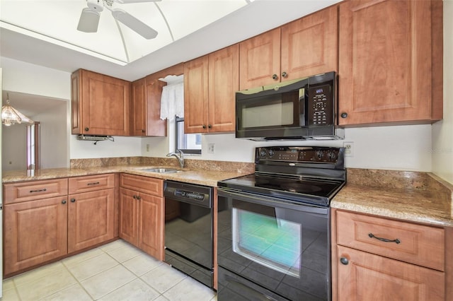 kitchen with brown cabinets, a sink, black appliances, and light tile patterned floors