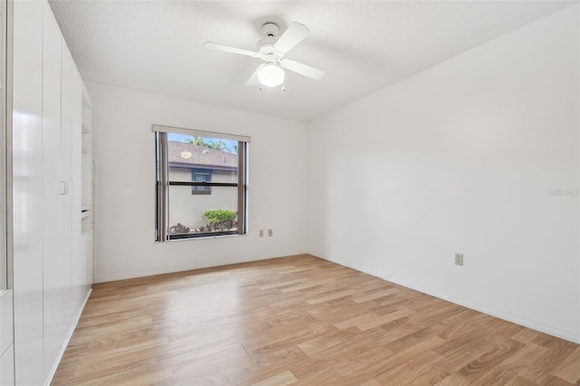 unfurnished room featuring light wood-style floors, a textured ceiling, and a ceiling fan