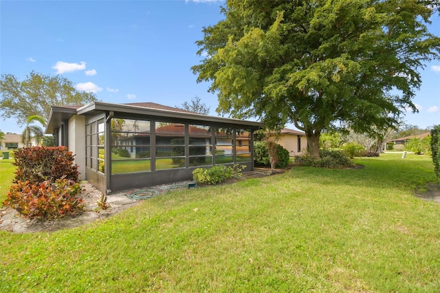 rear view of property featuring a sunroom and a lawn