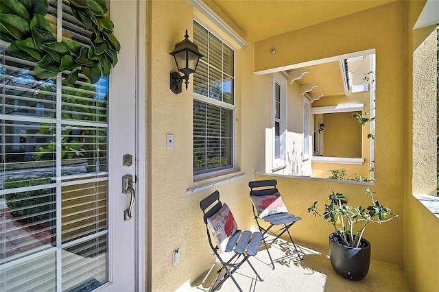 property entrance featuring a balcony and stucco siding