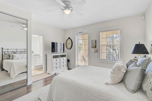 bedroom featuring ceiling fan, ensuite bath, and wood finished floors