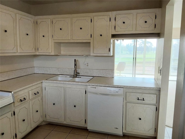 kitchen featuring light countertops, dishwasher, a sink, and light tile patterned flooring