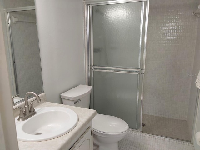 bathroom featuring toilet, a stall shower, tile patterned flooring, and vanity