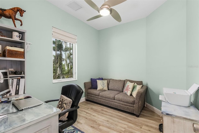 home office with light wood-type flooring, baseboards, visible vents, and a ceiling fan