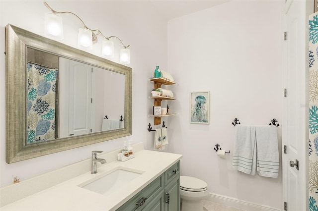 bathroom featuring toilet, vanity, and baseboards