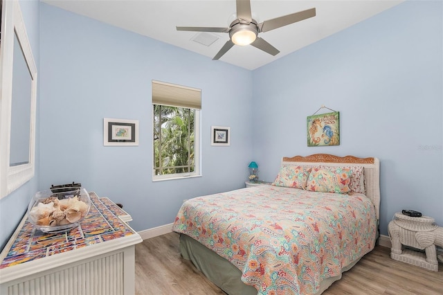 bedroom with ceiling fan, light wood-type flooring, and baseboards