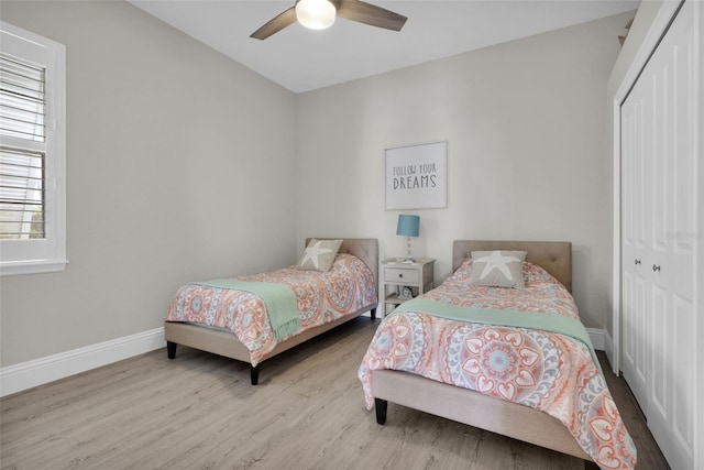 bedroom featuring a ceiling fan, baseboards, a closet, and wood finished floors