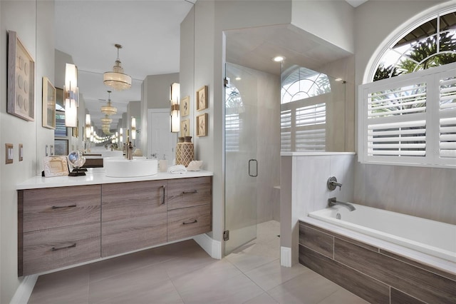 bathroom with a garden tub, a notable chandelier, a stall shower, vanity, and tile patterned flooring