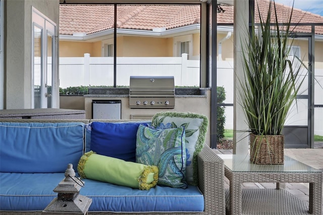 view of patio with fence, an outdoor living space, exterior kitchen, and area for grilling