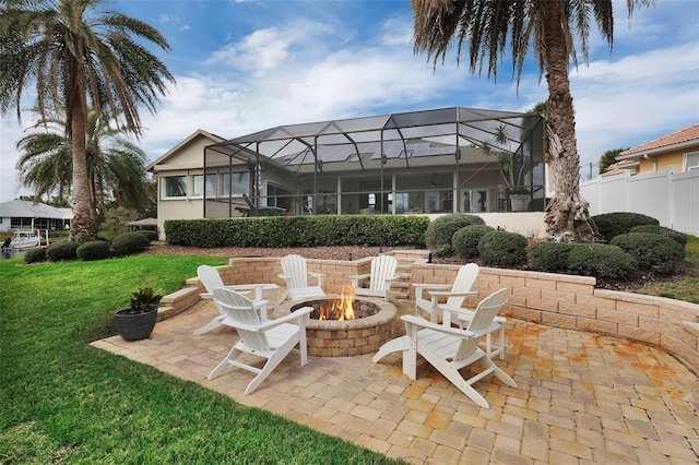 view of patio featuring glass enclosure, an outdoor fire pit, and fence