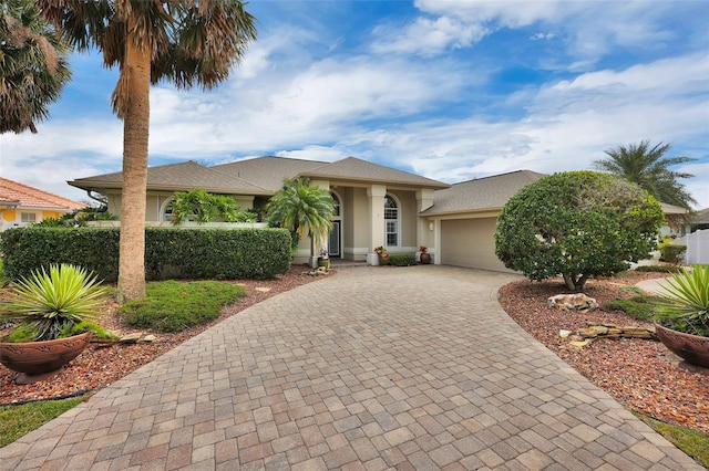 view of front of house featuring a garage, decorative driveway, and stucco siding