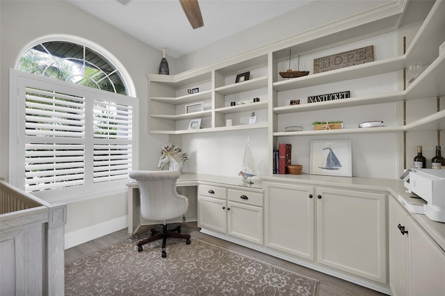 home office featuring built in desk, light wood-type flooring, and baseboards