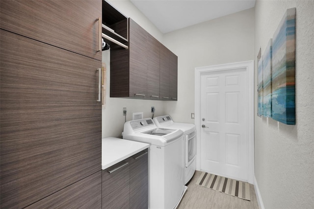 laundry area with cabinet space and separate washer and dryer