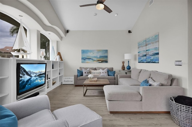 living room featuring light wood-style floors, ceiling fan, visible vents, and high vaulted ceiling