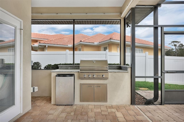 view of patio / terrace with a lanai, fence, grilling area, and area for grilling