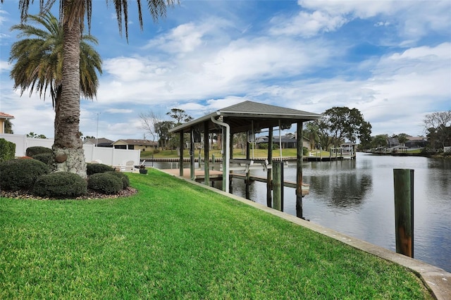 dock area featuring a water view, a yard, and boat lift