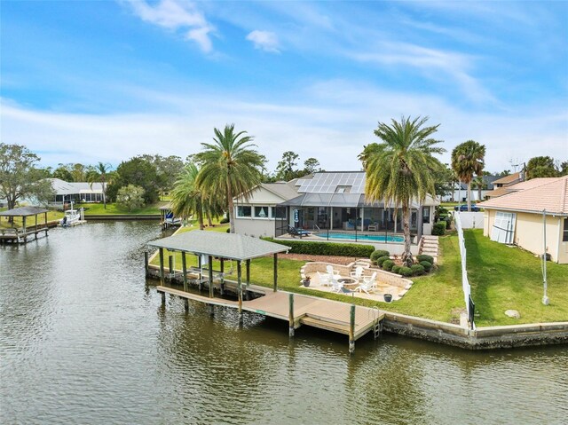 view of dock featuring boat lift, a water view, a lawn, glass enclosure, and an outdoor pool