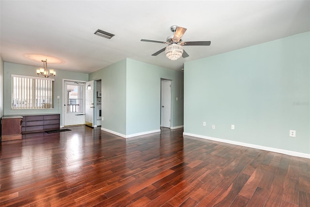 unfurnished room featuring ceiling fan with notable chandelier, visible vents, baseboards, and wood finished floors