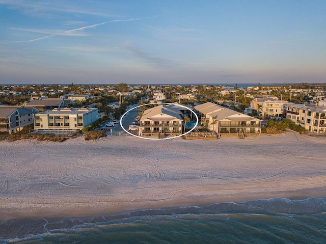 birds eye view of property with a water view and a beach view