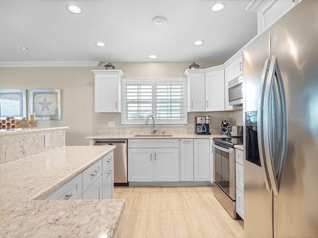 kitchen featuring appliances with stainless steel finishes, a sink, and white cabinets