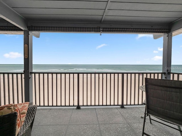 balcony with a water view and a beach view