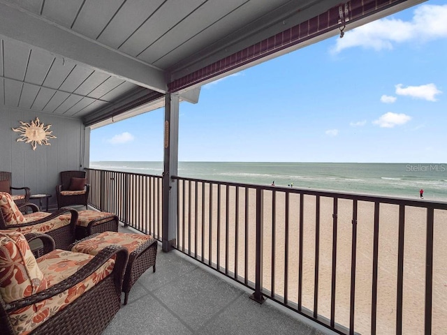 balcony featuring a water view and a view of the beach