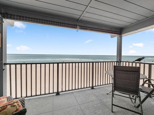 balcony featuring a water view and a view of the beach