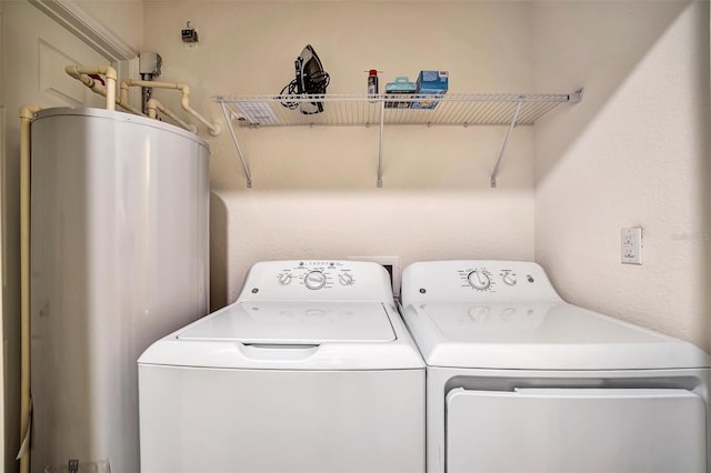 clothes washing area with laundry area, independent washer and dryer, and gas water heater