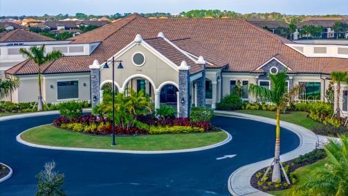 mediterranean / spanish-style home featuring a front lawn, curved driveway, and a tile roof