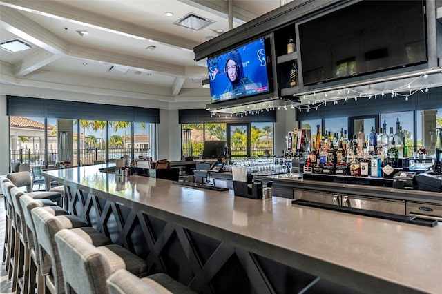 bar featuring coffered ceiling, beam ceiling, visible vents, and a bar