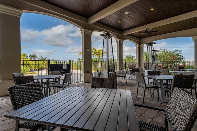 wooden deck featuring outdoor dining area, ceiling fan, and a patio