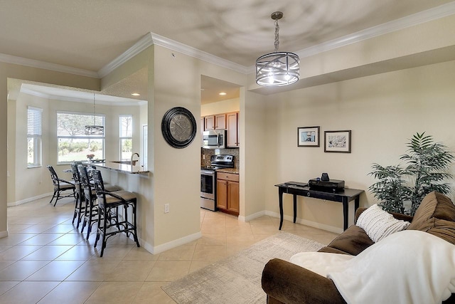 kitchen with appliances with stainless steel finishes, light tile patterned flooring, ornamental molding, and a breakfast bar area