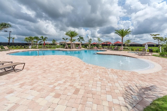 community pool featuring a patio area and fence