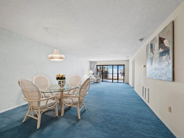 carpeted dining area featuring visible vents and a textured ceiling