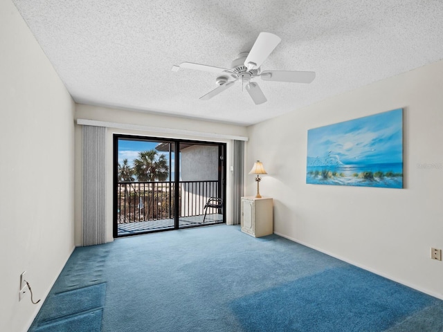 carpeted spare room with a ceiling fan and a textured ceiling