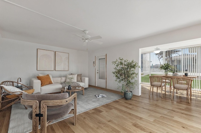 living area featuring light wood-type flooring and ceiling fan