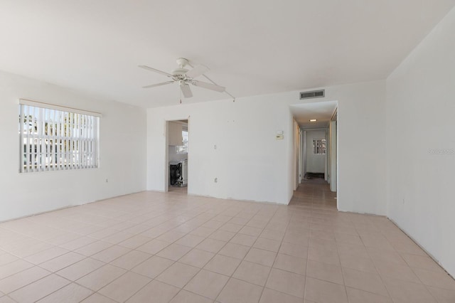 unfurnished room featuring a ceiling fan, visible vents, and light tile patterned floors