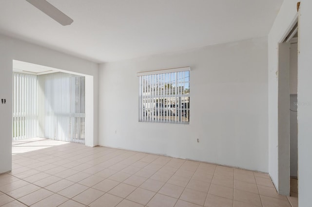 spare room with a ceiling fan and light tile patterned flooring