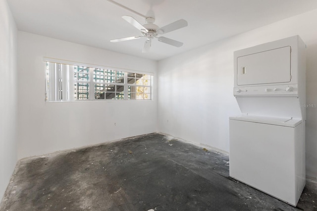 spare room with ceiling fan, stacked washer and dryer, and concrete floors