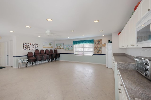 kitchen with a toaster, recessed lighting, white cabinets, white appliances, and baseboards