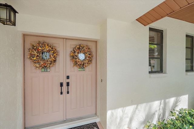 view of exterior entry with stucco siding