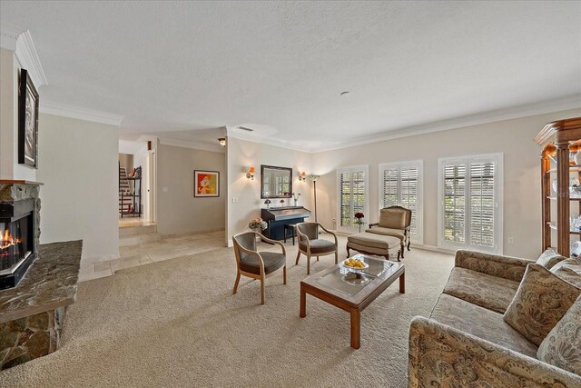 living area featuring light carpet, ornamental molding, a textured ceiling, and a glass covered fireplace