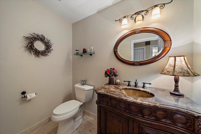 bathroom featuring vanity, toilet, and baseboards