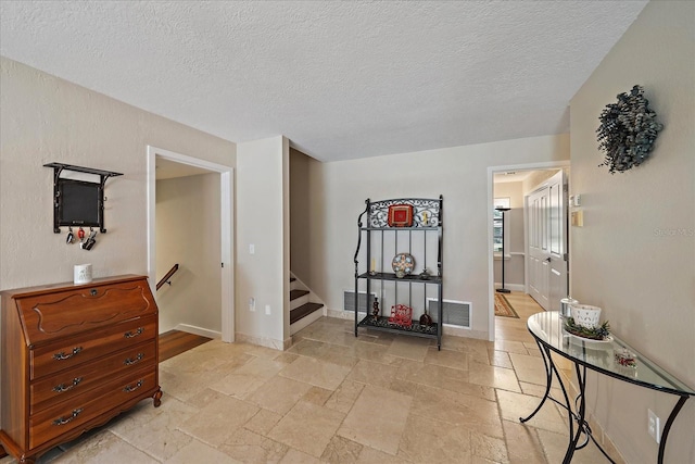 interior space featuring baseboards, stairs, visible vents, and stone tile floors