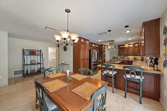 dining space with stone tile flooring, visible vents, and an inviting chandelier