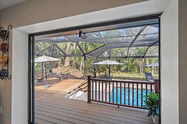 wooden deck with a lanai and an outdoor pool